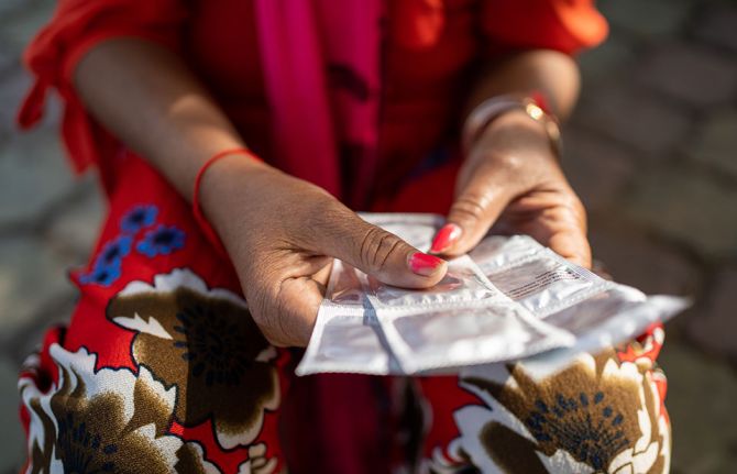 A street vendor holds some free condoms on the street in Phnom Penh, Cambodia on December 4, 2019. ©UNAIDS Cambodia/2019/Todd Brown