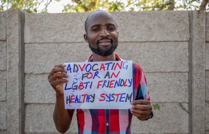 Calvin Mapangisana, a counsellor at the Gays and Lesbians of Zimbabwe (GALZ) association holds up a message on a placard at the GALZ drop-in centre in Mutare, Zimbabwe. 